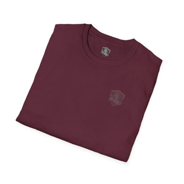 A folded maroon "You Saw It Because We Brought It" T-shirt featuring a small logo on the left chest and a shield-shaped tag at the neckline.