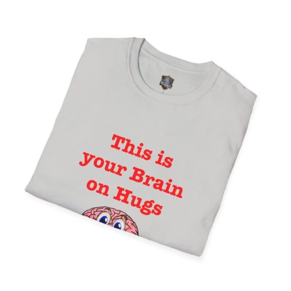 Folded 'This is Your Brain on Hugs' white T-shirt featuring red text and a partially visible illustrated brain with eyes at the bottom.