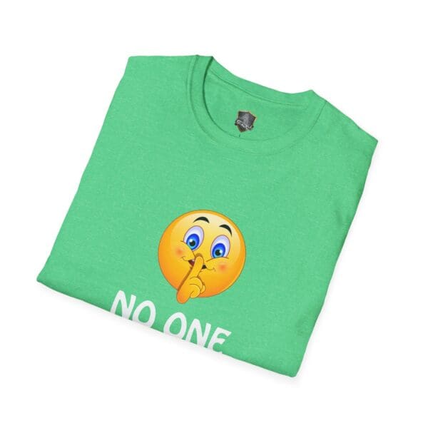 A folded "No One Cares" green T-shirt featuring an emoji making a shushing gesture.