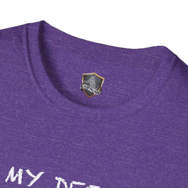 Close-up of a purple Unsupervised Mischief T-Shirt featuring a shield-shaped tag labeled "Chipmunk" on the inside collar, with partially visible white text on the shirt.