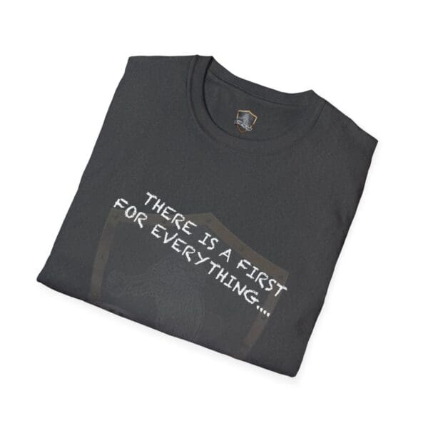 A dark T-shirt neatly folded, displaying the text "THERE IS A FIRST FOR EVERYTHING..." in white letters on the front, called "There's a First for Everything... Except Impressions! T-Shirt.