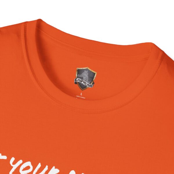 Close-up of an orange "Lunchbox Logic Tee" with a label reading "CHIPMUNK" and "L 100% Cotton." The shirt's collar and part of a white text are visible.