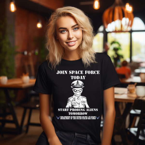 In a cafe, a person smiles while wearing the "Join Space Force Today" Alien T-Shirt.