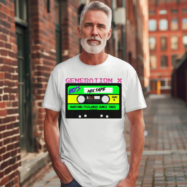 A man stands in a brick alley wearing the Generation X Tape T-Shirt, featuring a cassette tape design with the words "Generation X" and "80’s Mixtape - Hurting Feelings Since 1985.